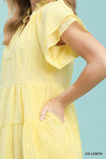 Yellow dress with ruffled sleeves on a light blue background