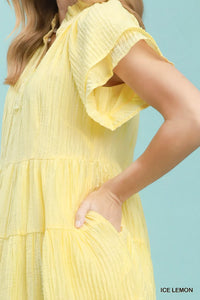 Yellow dress with ruffled sleeves on a light blue background
