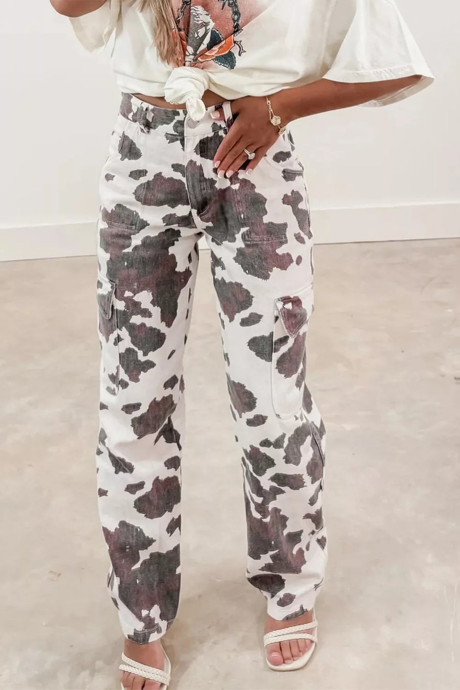 Person wearing floral pants and a white top in a minimal indoor setting