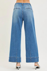 Blue jeans worn by a person on a white background