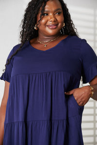 Woman wearing a navy blue dress with a plain background