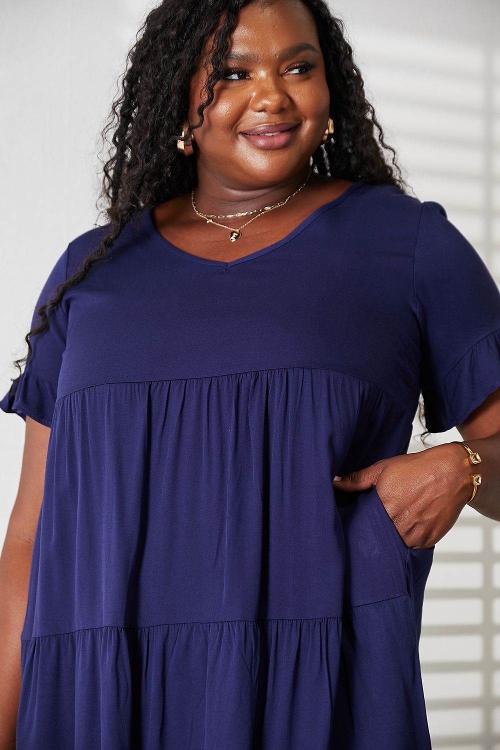 Woman wearing a navy blue dress with a plain background