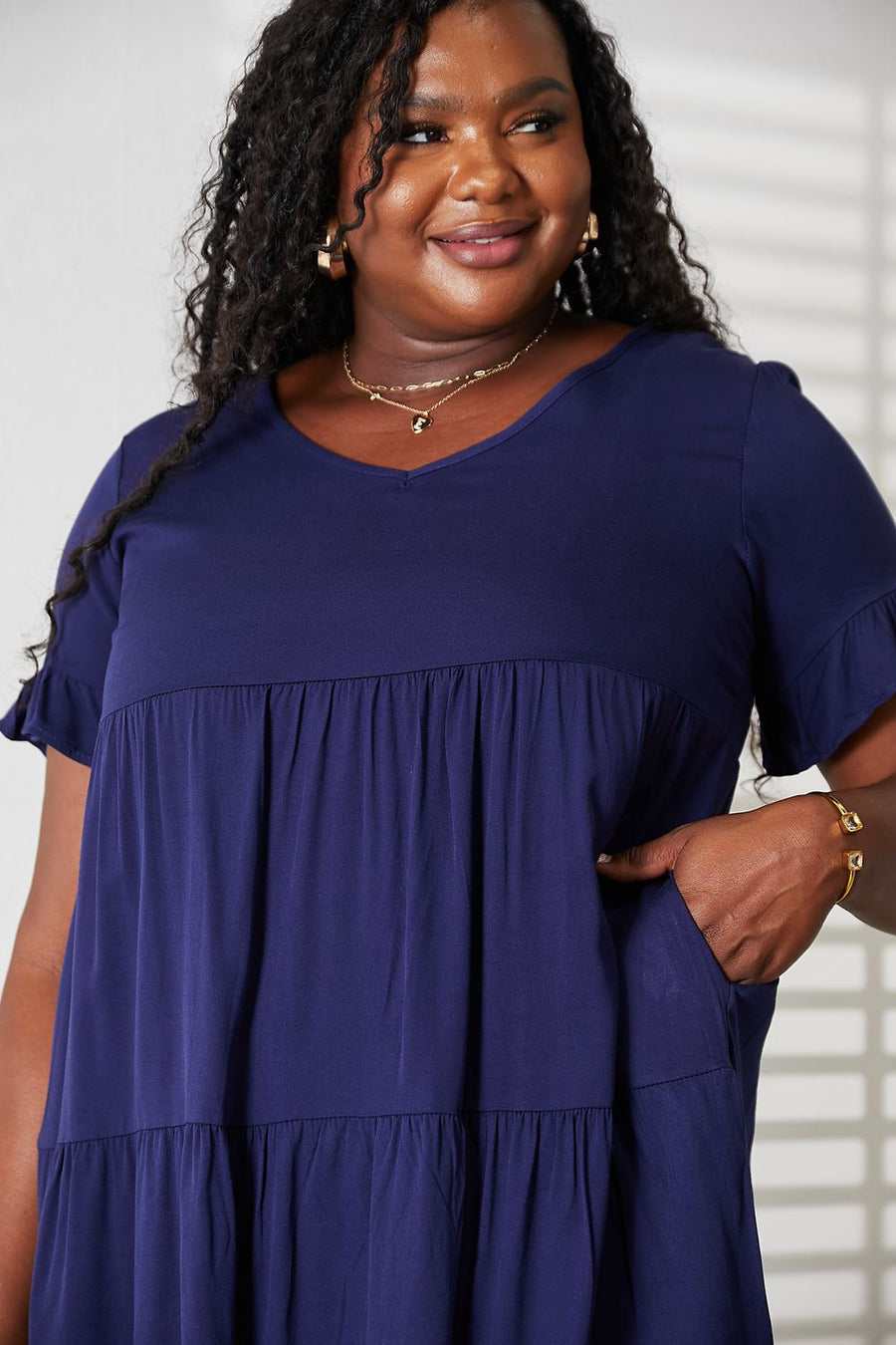 Woman wearing a navy blue dress with a plain background