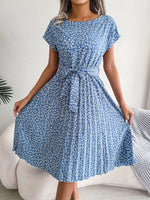 Woman wearing a blue floral dress with a white background