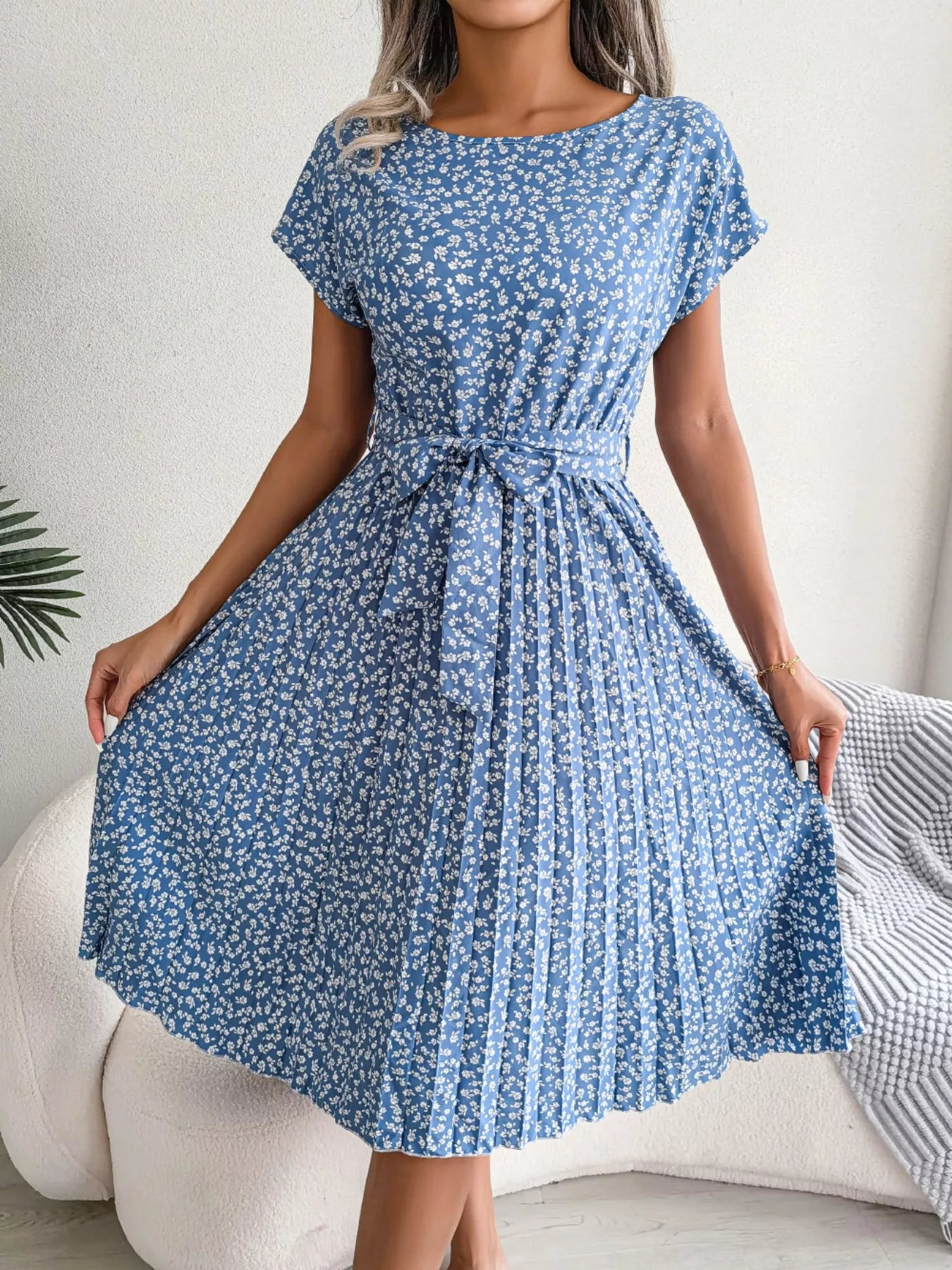Woman wearing a blue floral dress with a white background