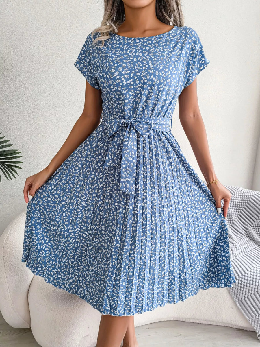 Woman wearing a blue floral dress with a white background
