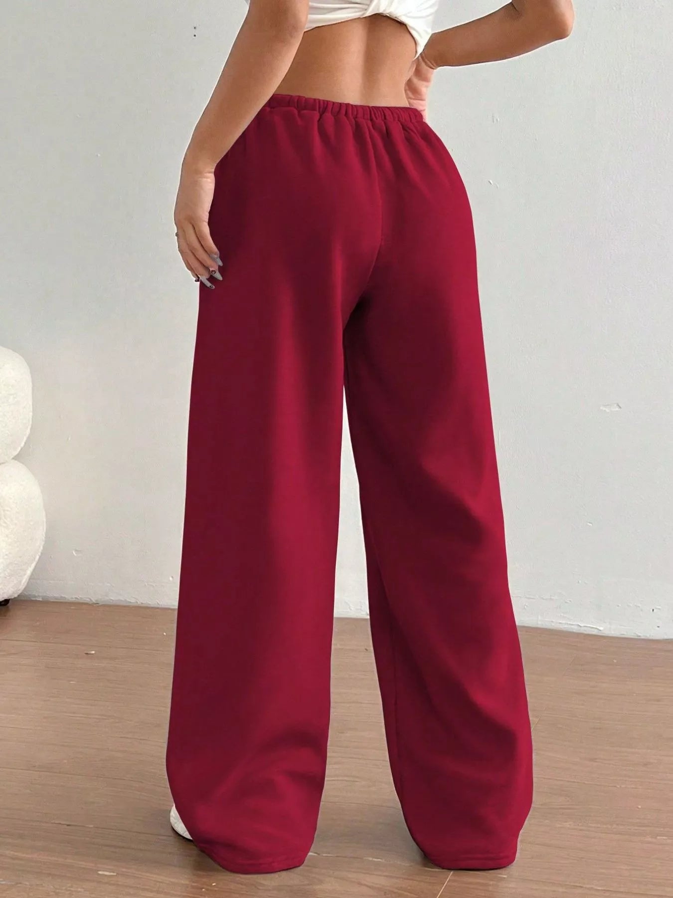 Red wide-leg pants worn by a person on a plain background