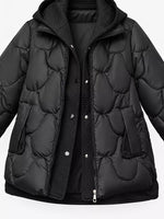 A black quilted puffer jacket with a hood, featuring a front zipper and snap-button closure over a matching black ribbed inner layer, shown against a plain white background.