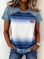 Woman wearing a blue and white striped shirt with denim accents on a plain background