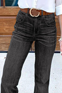 Person wearing dark jeans with a belt in an outdoor setting