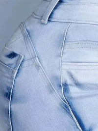 Close-up of a light blue denim fabric with a pocket and stitching detail.
