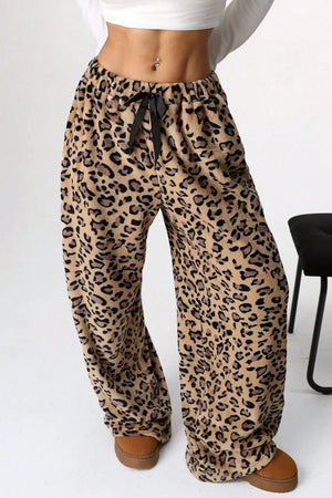 Leopard print pants worn by a person on a white background