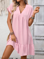 Woman wearing a pink dress with a neutral background
