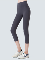 Person wearing dark gray leggings on a light gray background