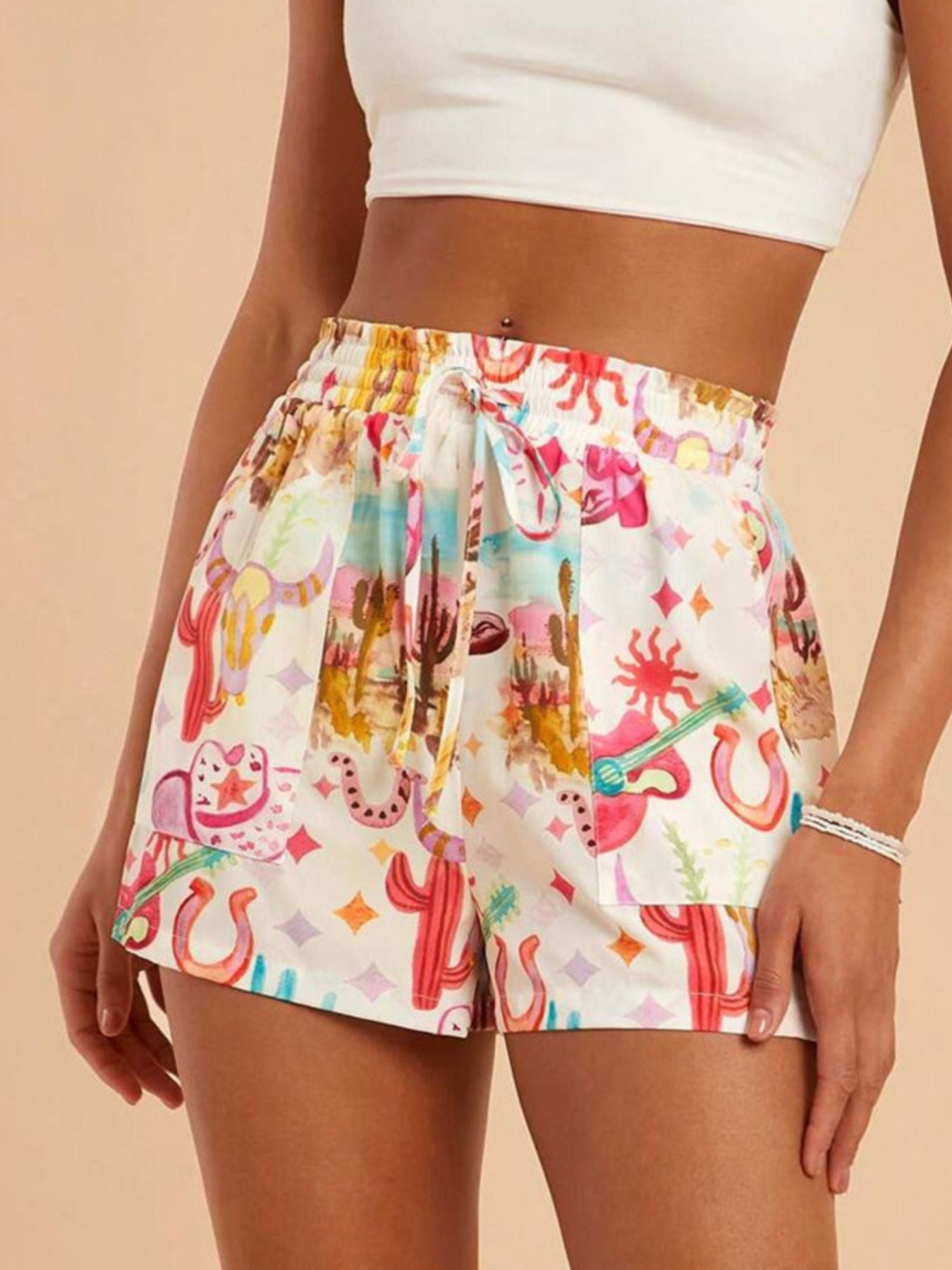 Colorful cactus-patterned shorts worn by a person on a beige background