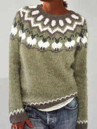 Person wearing a green knitted sweater with a white pattern on a plain background