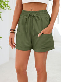 Green shorts worn by a person on a white background
