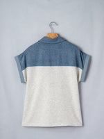 Two-tone blue and gray shirt on a hanger against a light gray background
