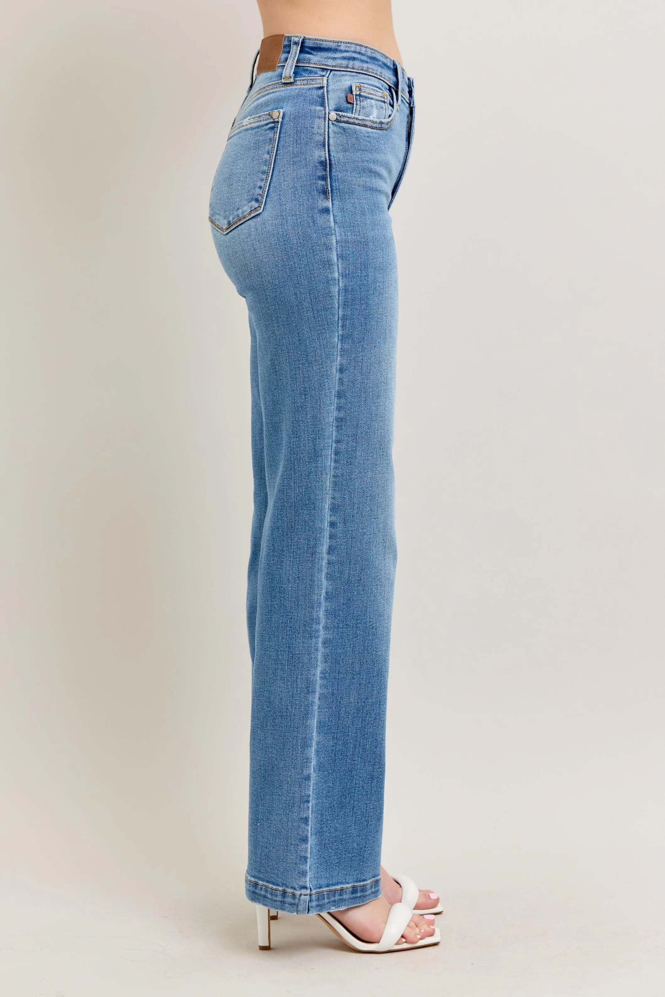 Light blue jeans worn by a person on a plain background