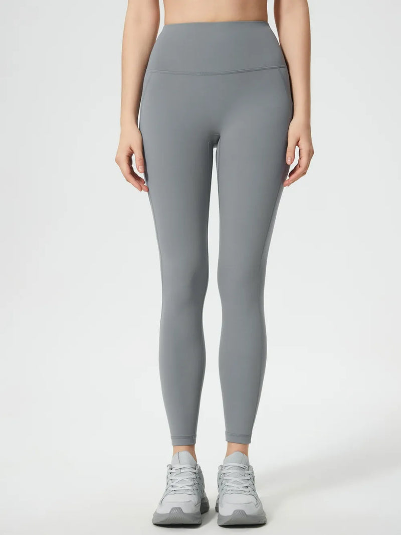 Person wearing gray leggings on a white background