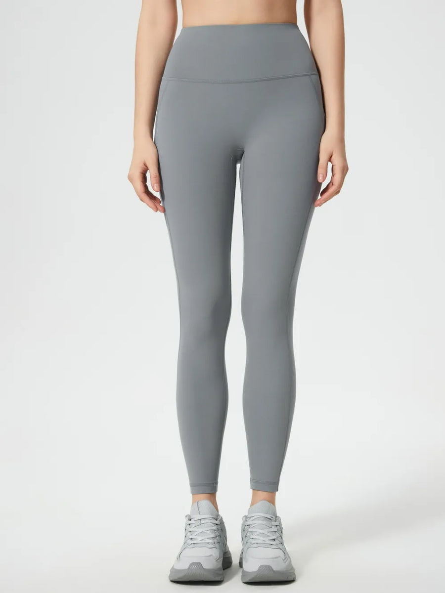 Person wearing gray leggings on a white background