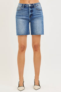 Blue denim shorts worn by a person on a white background
