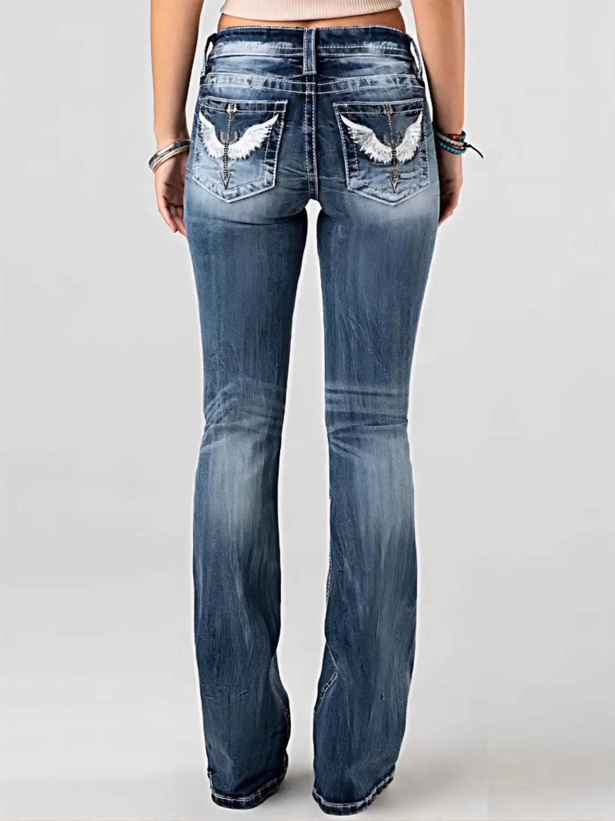 Blue jeans with decorative patches on the back pockets against a white background