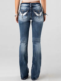 Blue jeans with decorative patches on the back pockets against a white background