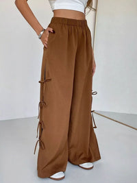 Brown wide-leg pants with tie details on a white background