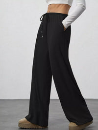 Black wide-leg pants worn by a person on a plain background