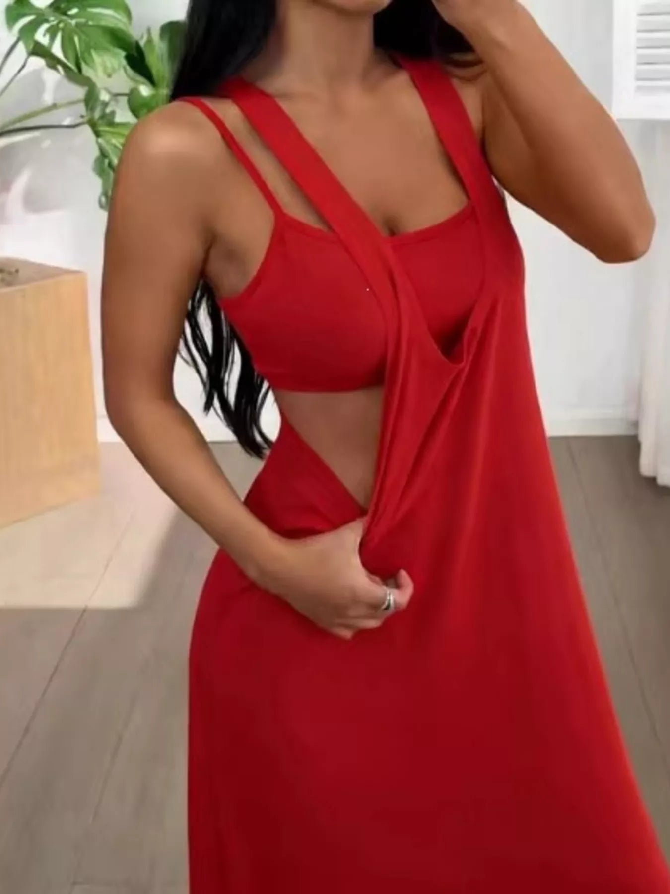 Woman wearing a red dress with cut-out design indoors.