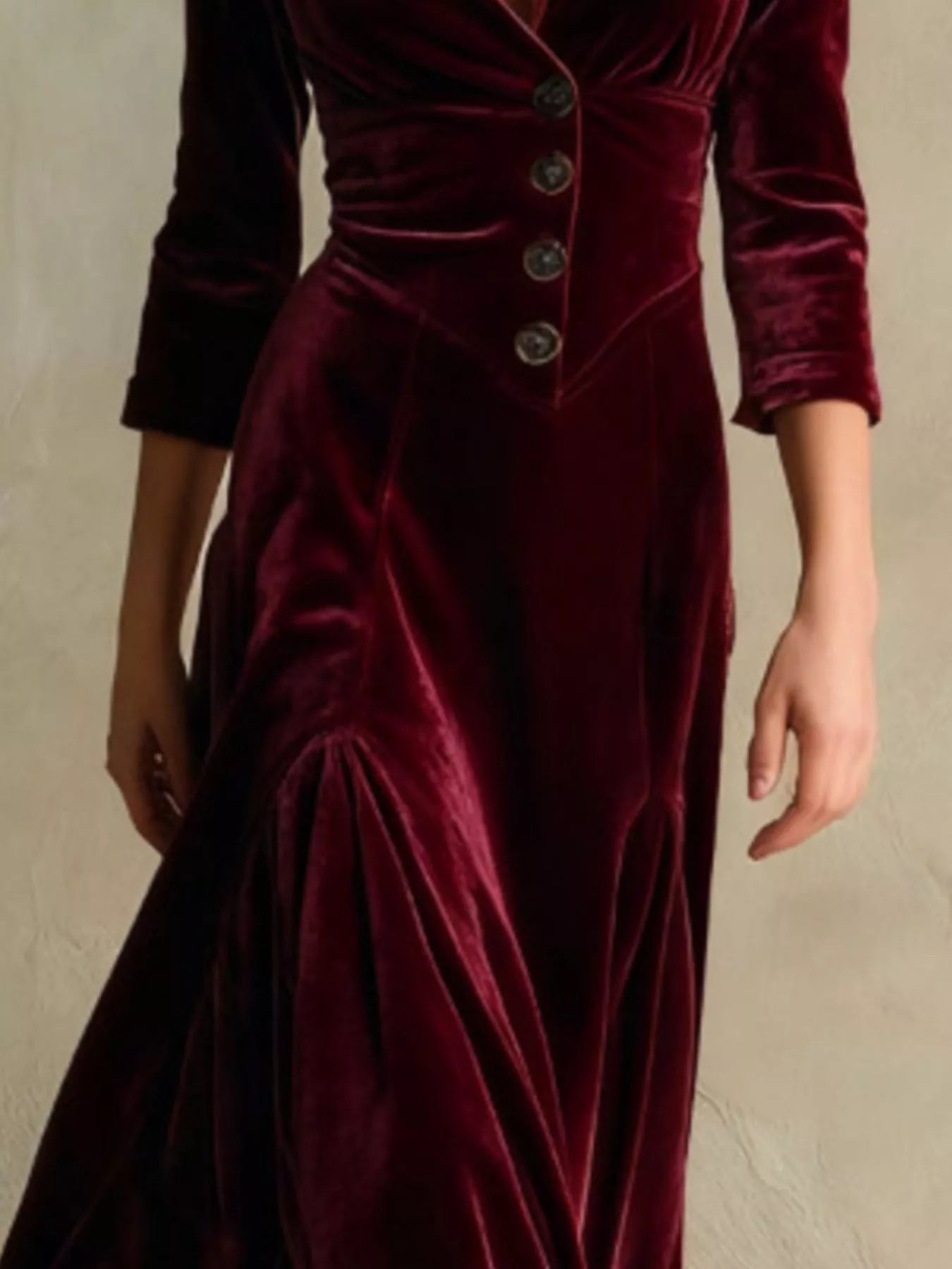 Maroon velvet dress with buttons on a neutral background