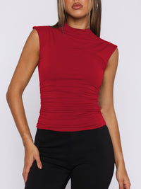 Red sleeveless top worn by a person on a white background
