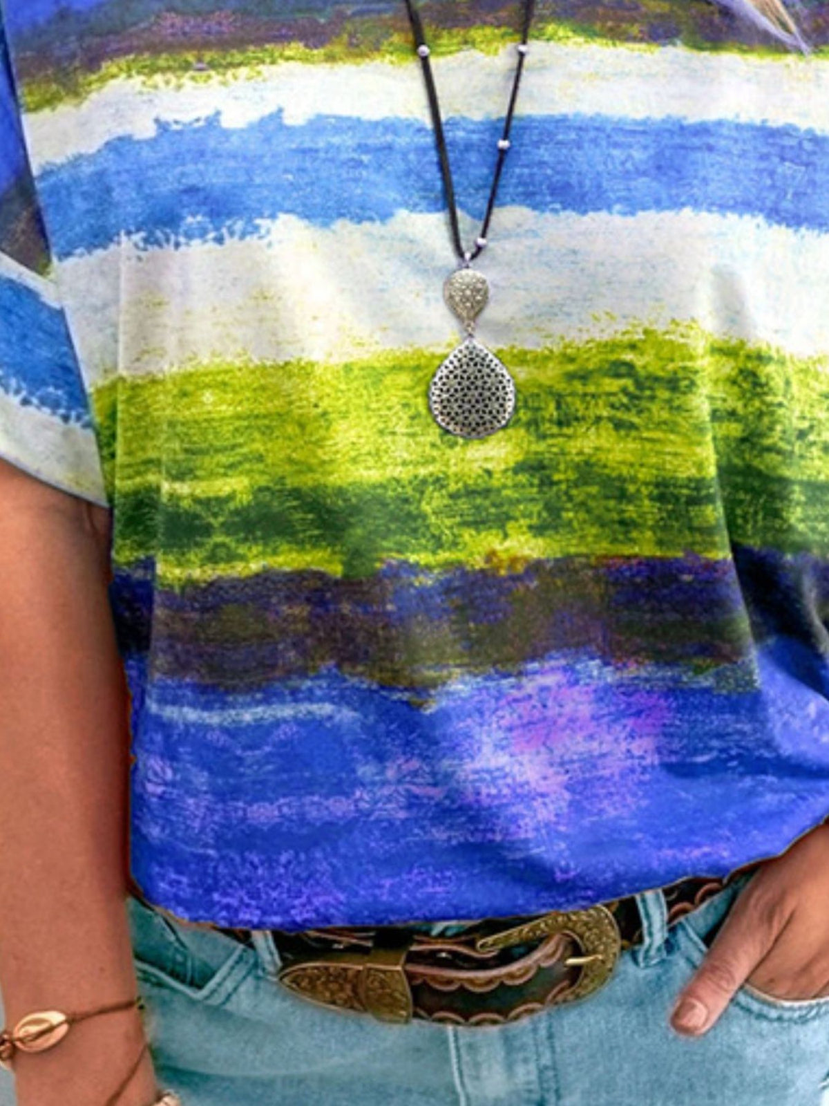 Person wearing a colorful striped shirt with a necklace