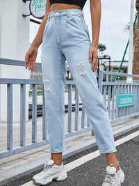 Person wearing light blue jeans with a slight crop, standing on a street.