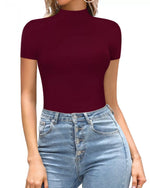 Person wearing a burgundy short-sleeve top and blue jeans on a white background