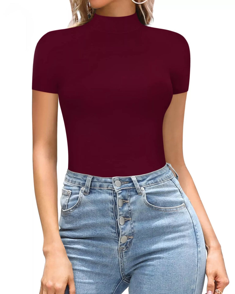 Person wearing a burgundy short-sleeve top and blue jeans on a white background