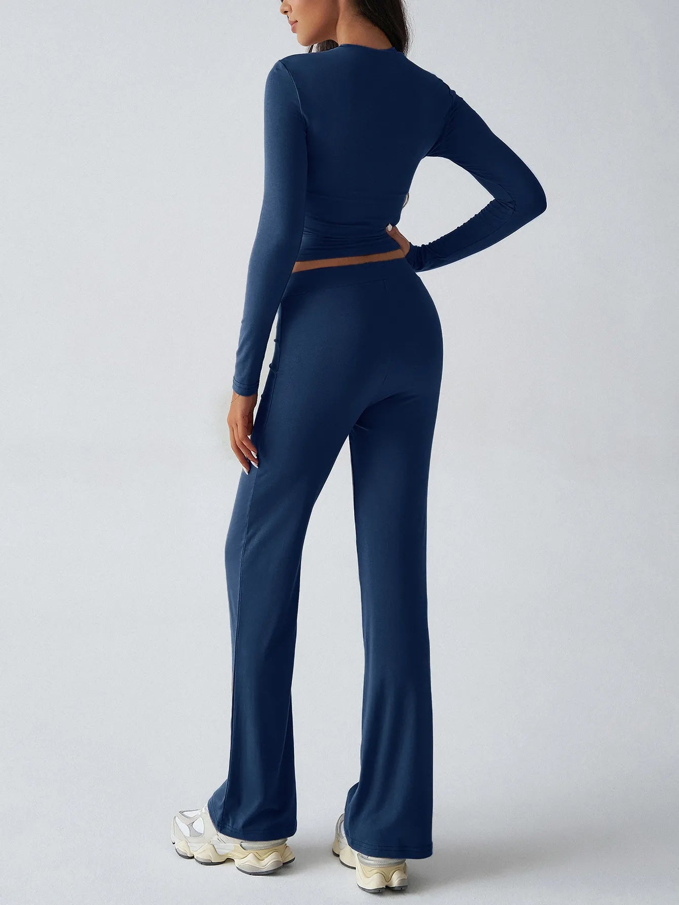 Person wearing a navy blue athletic outfit on a light gray background