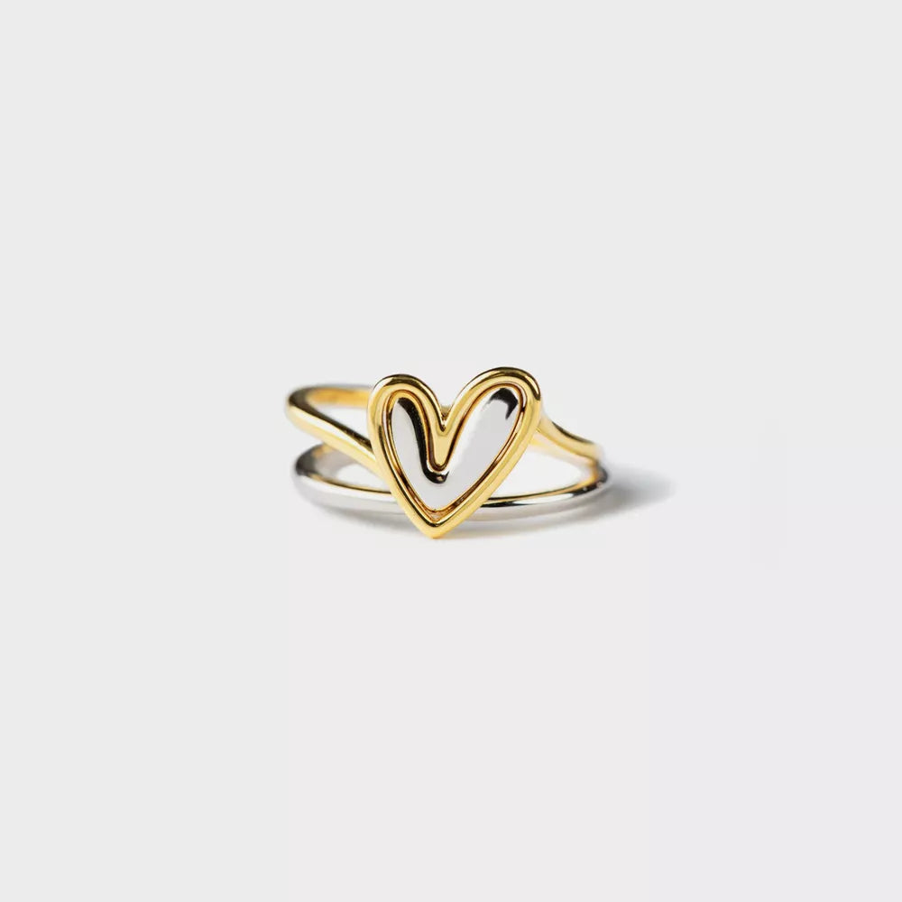 Gold heart-shaped ring on a light gray background