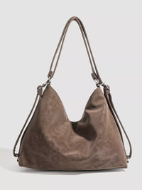 Brown leather handbag on a light gray background