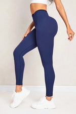 Person wearing navy blue leggings with a plain background