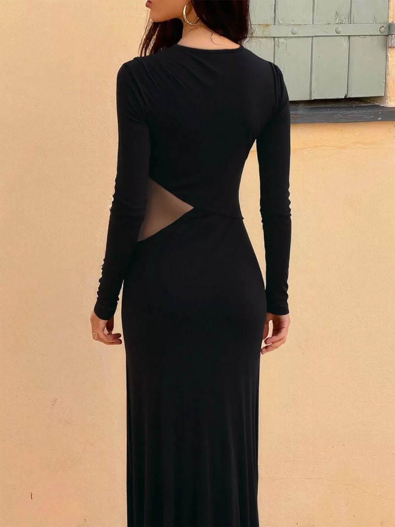 Black long-sleeve dress with cut-out design on a beige wall background