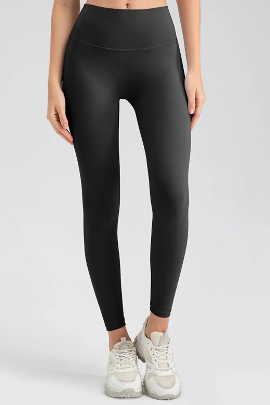 Person wearing black leggings on a white background
