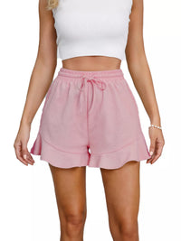 Person wearing pink shorts and a white top on a white background