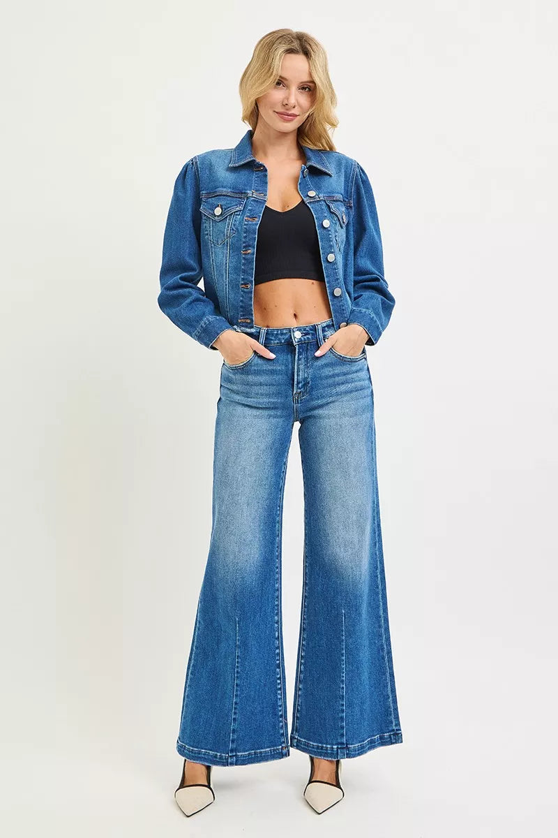Woman wearing a blue denim jacket and jeans on a white background
