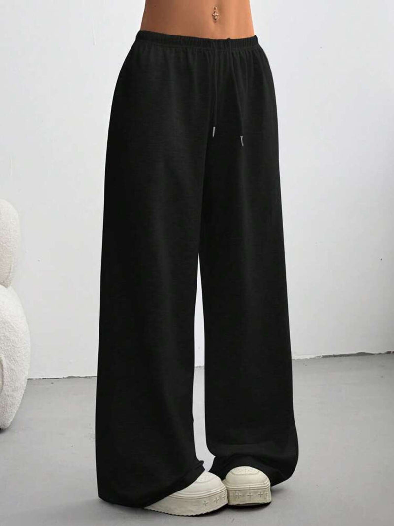 Black wide-leg pants worn by a person on a plain background
