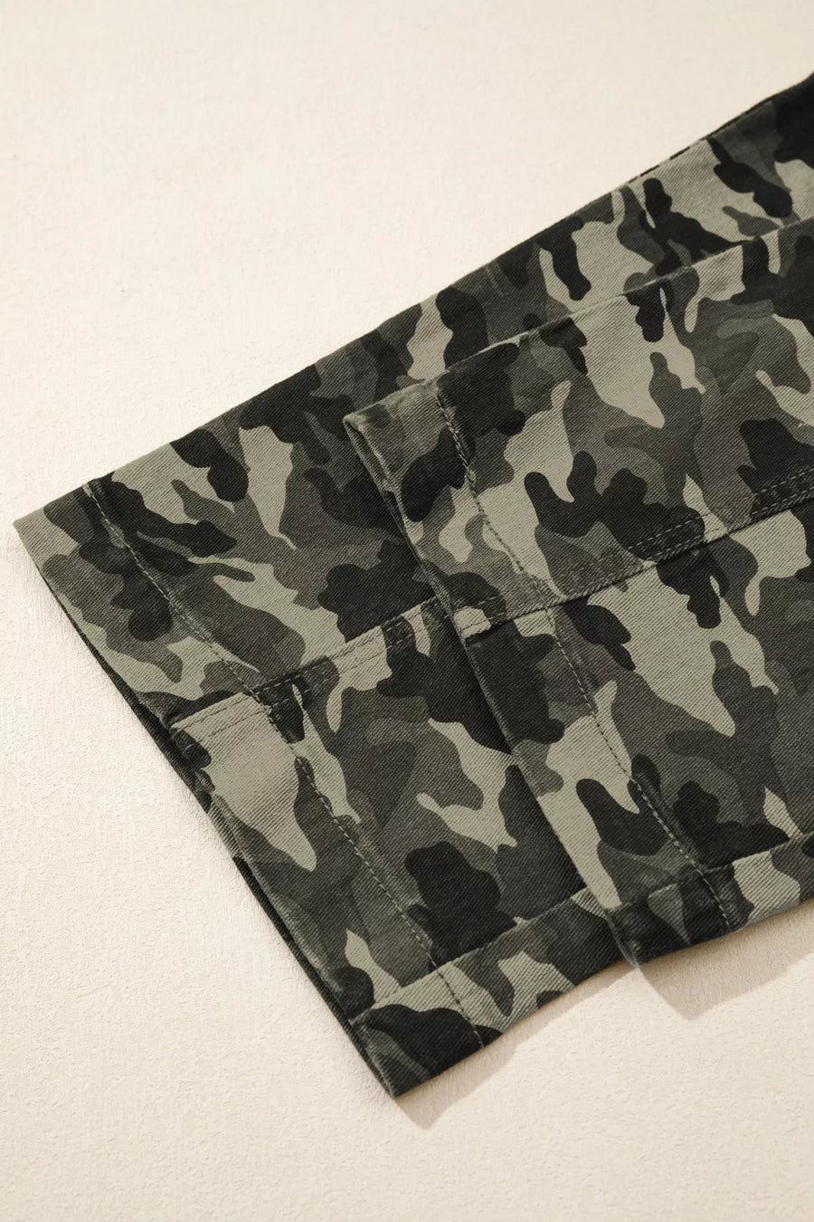 Camouflage-patterned pants on a light beige background