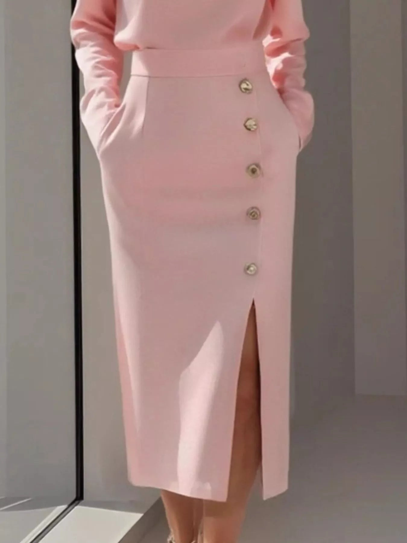 Pink skirt with button details on a plain background