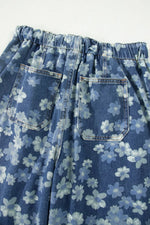 Blue denim skirt with white floral pattern on a white background