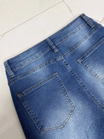 Close-up of blue denim jeans on a white surface